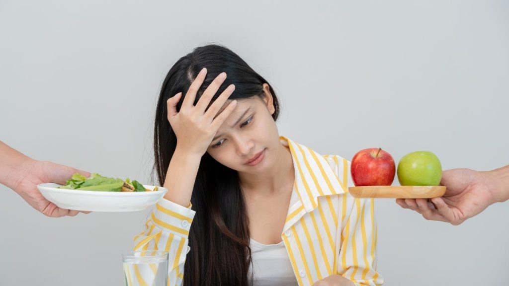 食べるのを我慢している女性