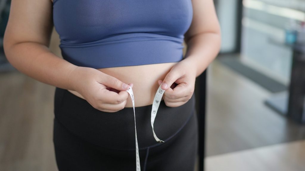 ウエストを測っている女性