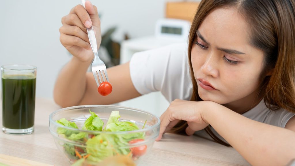 ミニトマトをフォークで刺している女性